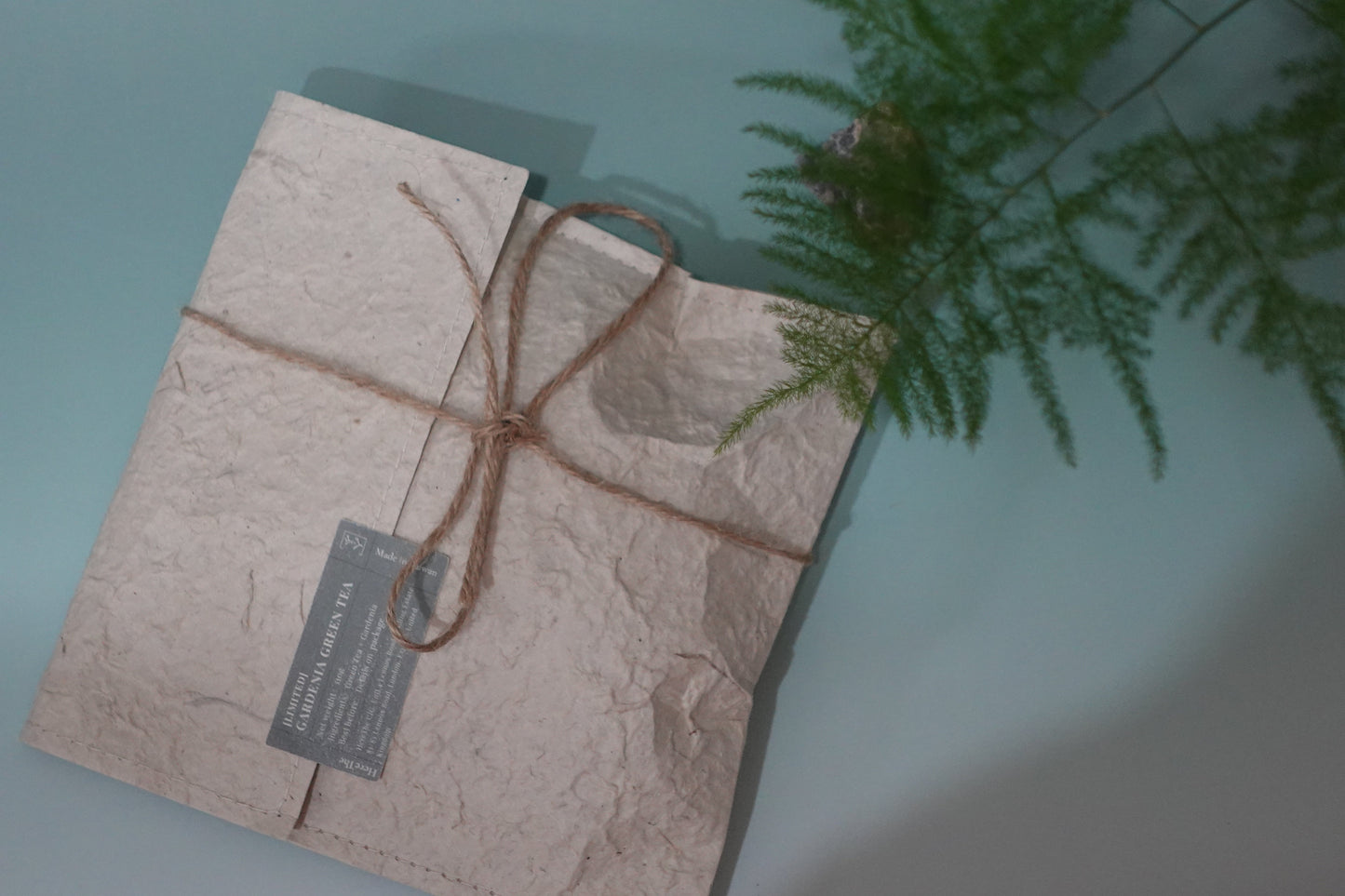 Package wrapped in brown paper with string on a light blue background