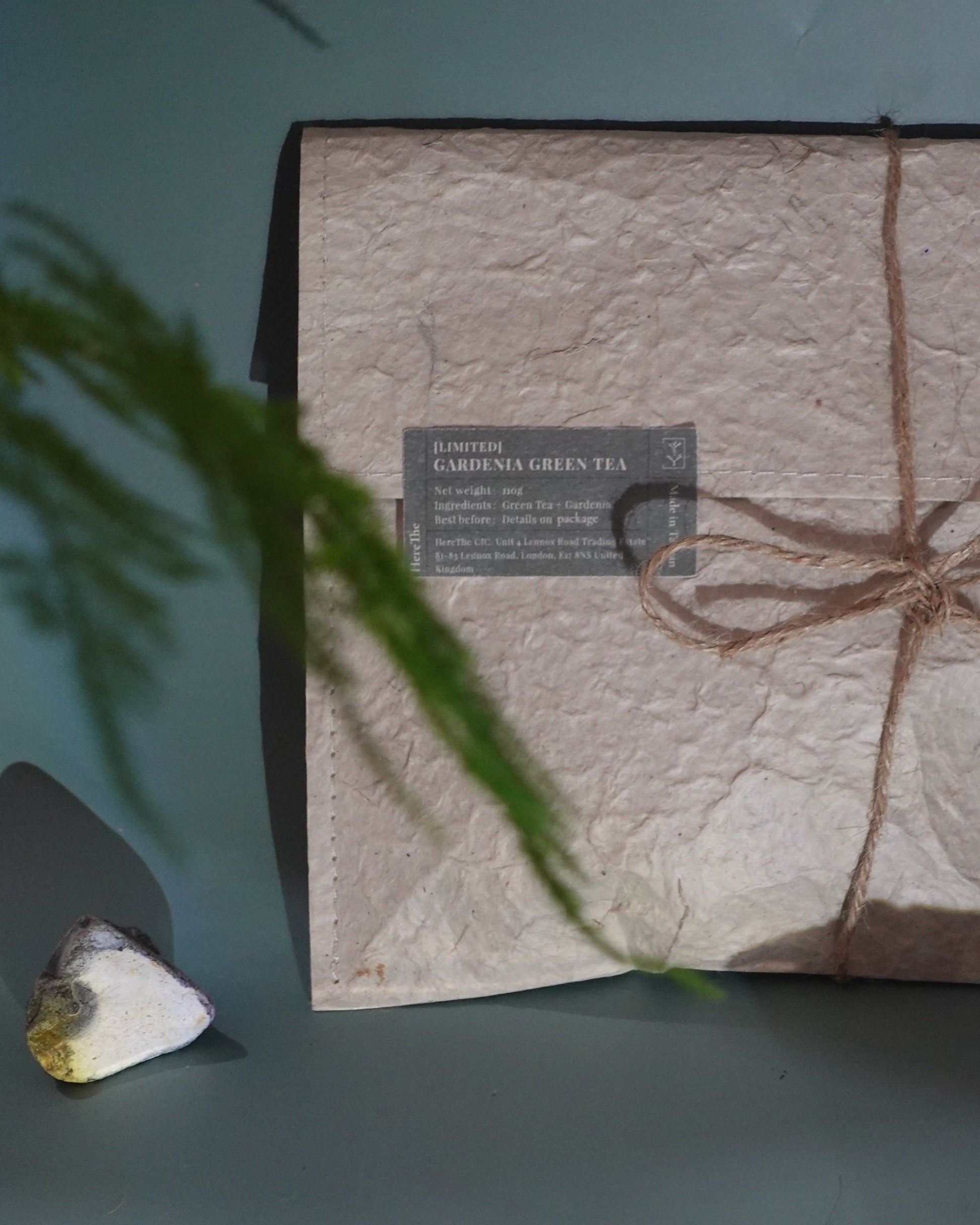 Product packaging with textured surface and twine bow on a gray background