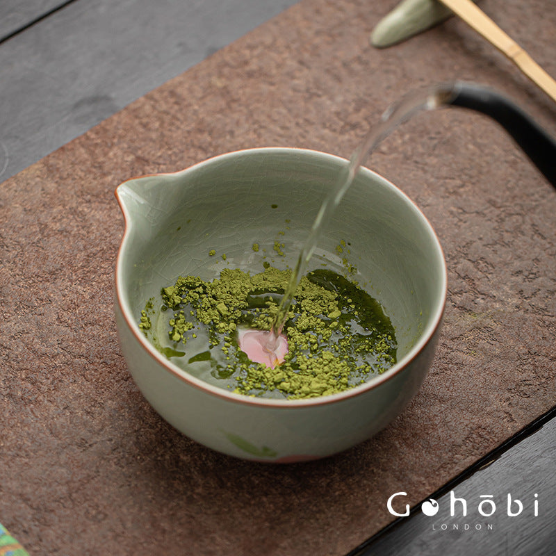 Matcha being poured into a ceramic bowl on a wooden surface with 'Gohabi London' branding.