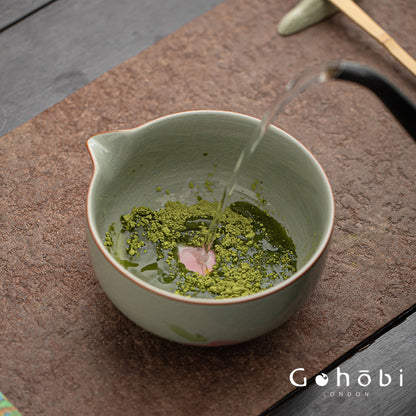 Matcha being poured into a ceramic bowl on a wooden surface with 'Gohabi London' branding.